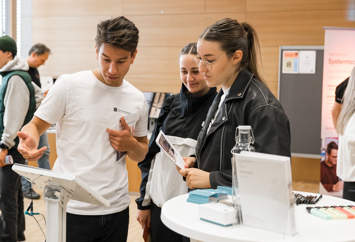 Impression von der Check it Out, Besucher wird am Stand beraten.  | © Nina Bröll und FHV