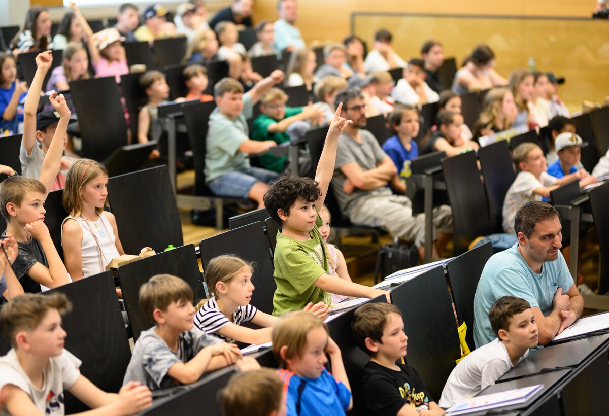 Kinder zeigen in der Kinder Uni auf und machen mit beim Vortrag.  | © FHV / Mattias Rhomberg