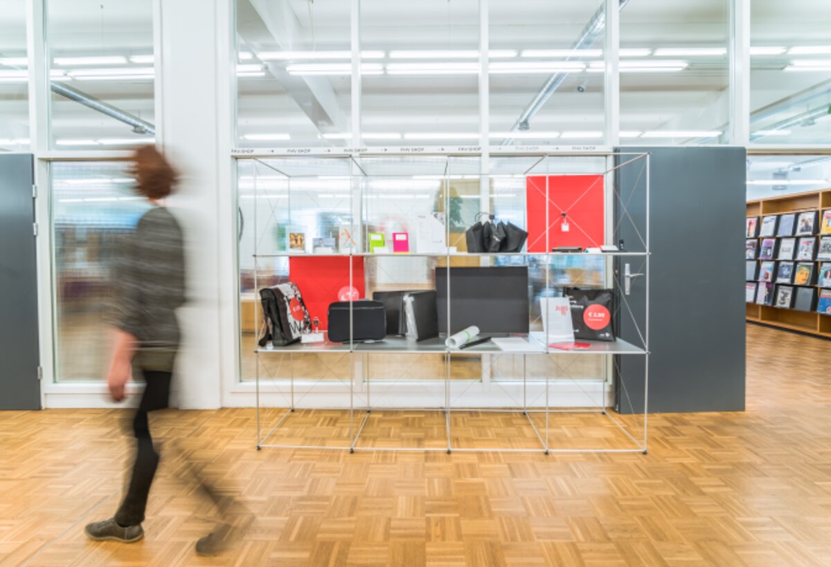 Shelf with shop articles from the FHV shop with a person walking past in the foreground | © Fabrizio Prizi & FHV