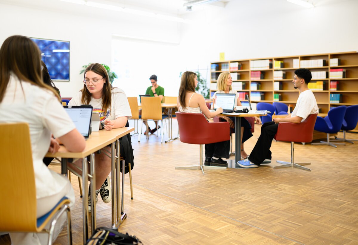 Students sit in the magazine area of the library. | © Matthias Rohmberg & FHV