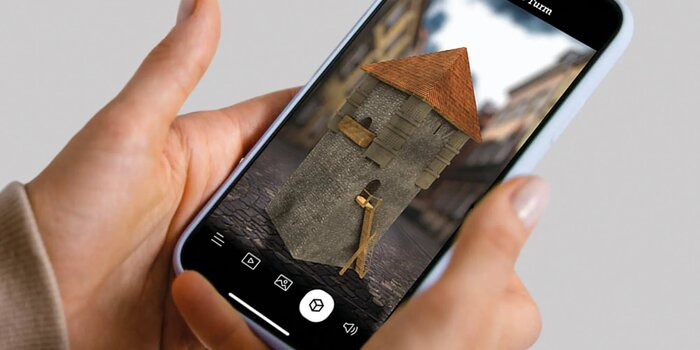 Iphone in Hand mit Augmented Reality Gebäude auf dem Screen | © FHV
