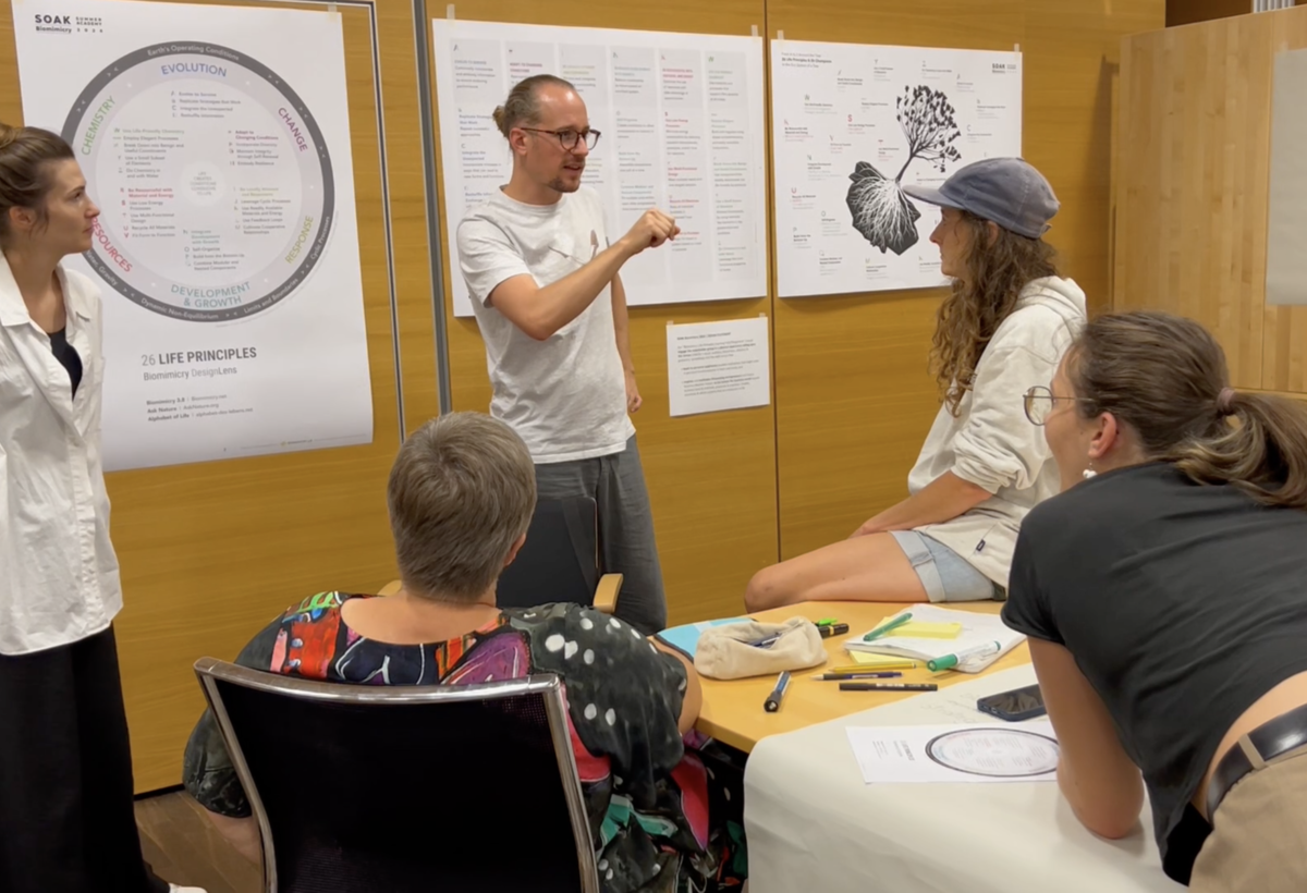 Unterschiedliche Menschen diskutieren vor diversen Plakaten | © Fachbereich Gestaltung, FHV