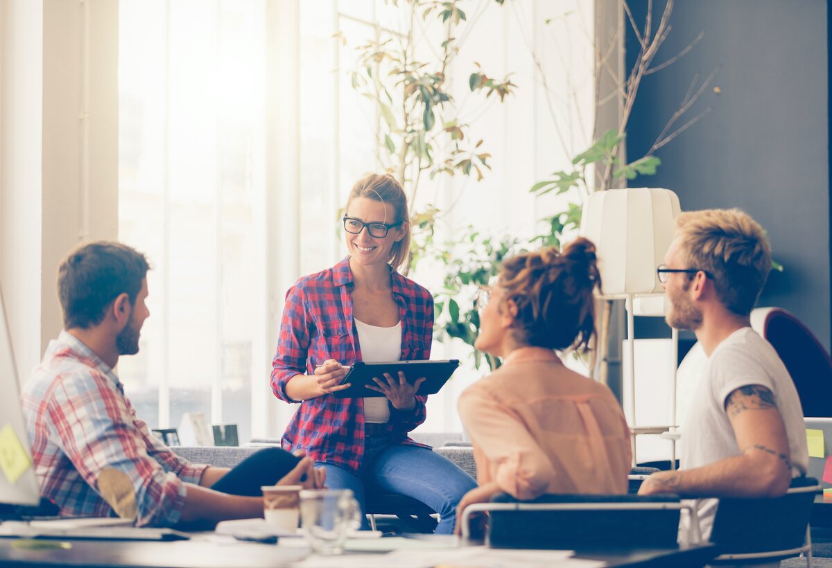 Eine Gruppe von Menschen sitzt im Gespräch zusammen und arbeitet gemeinsam. | © Adobe Stock