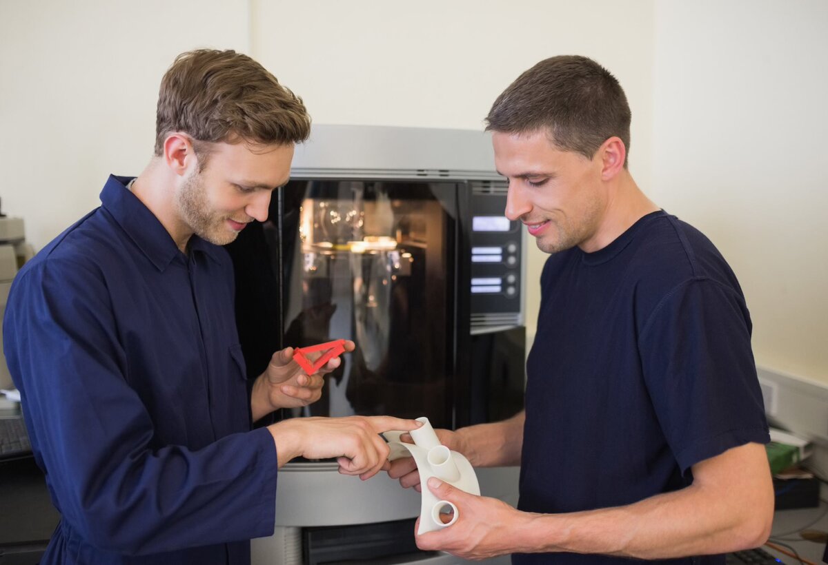 zwei Männer sehen einen 3D Druck an