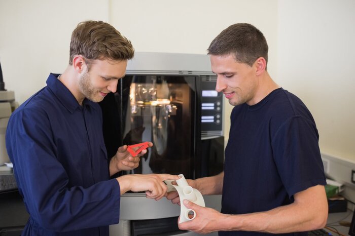 zwei Männer sehen einen 3D Druck an