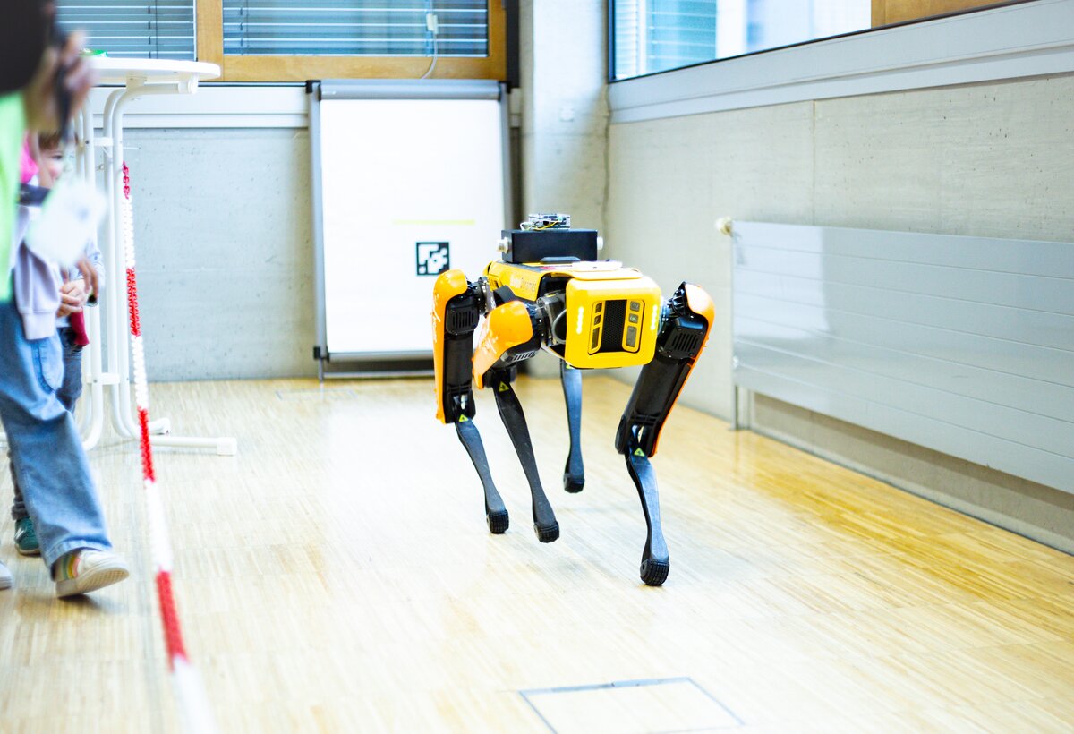 Roboterhund SPOT von Boston Dynamics läuft zwischen einer Menschengruppe | © Johanna Eppler